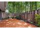 Secluded brick patio surrounded by a wooden fence and mature trees, perfect for outdoor relaxation at 433 The North Chace, Atlanta, GA 30328
