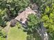 Aerial view of home, manicured lawn, long driveway, garage, and trees at 1042 Bailey Rd, Woodstock, GA 30188