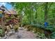 Serene backyard retreat showcasing a charming patio, lush landscaping, and a tranquil stream at 1042 Bailey Rd, Woodstock, GA 30188