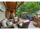 Inviting covered deck offers outdoor seating, dining area, and lush backyard views at 1042 Bailey Rd, Woodstock, GA 30188