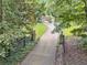 Long driveway leading to a home surrounded by lush greenery and mature trees at 1042 Bailey Rd, Woodstock, GA 30188