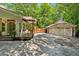 Large driveway leads to a detached two-car garage, next to pergola and outdoor seating at 1042 Bailey Rd, Woodstock, GA 30188