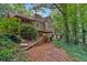Back exterior of home featuring covered porch and deck areas surrounded by lush landscaping at 1042 Bailey Rd, Woodstock, GA 30188