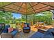 Inviting covered deck with seating area offers a peaceful view of lush greenery and trees at 1400 Land Rd, Canton, GA 30114