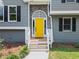 Close-up of a bright yellow front door with stone accents and white trim at 1400 Land Rd, Canton, GA 30114