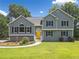 Charming two-story home with gray siding, black shutters and a welcoming yellow front door at 1400 Land Rd, Canton, GA 30114