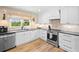 Updated kitchen features stainless steel appliances, black countertops, and stylish white cabinets at 1400 Land Rd, Canton, GA 30114