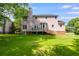 View of the home from the backyard, featuring a deck and lush green lawn at 3348 Summit Turf Ln, Snellville, GA 30078