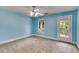 Bedroom with blue walls, a ceiling fan, carpet and a door with glass panes leading to the outside at 3348 Summit Turf Ln, Snellville, GA 30078