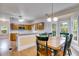 Open concept dining room and kitchen with hardwood floors and lots of natural light from surrounding windows at 3348 Summit Turf Ln, Snellville, GA 30078