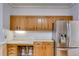 Kitchen with oak cabinets, bar stool seating, and a stainless steel refrigerator at 3348 Summit Turf Ln, Snellville, GA 30078
