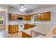 Kitchen boasts oak cabinets, white countertops, stainless steel microwave, and a view of the outdoors at 3348 Summit Turf Ln, Snellville, GA 30078