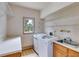 Bright laundry room features a modern washer and dryer, a utility sink, ample counter space, and a window at 3348 Summit Turf Ln, Snellville, GA 30078