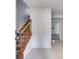 View of a home's staircase with neutral walls and a wood banister, leading to an open doorway at 3348 Summit Turf Ln, Snellville, GA 30078