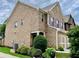 A tan brick house featuring meticulously maintained landscaping, a two-car garage, and a cozy front entrance at 3534 Clancy Way, Smyrna, GA 30080