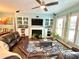 Bright living room with a fireplace, built-in shelves, and modern ceiling fan at 3534 Clancy Way, Smyrna, GA 30080
