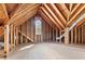 Spacious unfinished attic with exposed wood rafters and a window at 4042 Laurel Bend Ct, Snellville, GA 30039