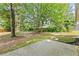 Large backyard featuring mature trees and a concrete patio at 4042 Laurel Bend Ct, Snellville, GA 30039