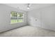 Bright bedroom with neutral carpet, ceiling fan, closet, and a window overlooking the backyard at 4042 Laurel Bend Ct, Snellville, GA 30039