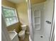 Well-lit bathroom featuring a modern shower, toilet, and vanity sink near a window at 410 S Gordon Sw Rd, Mableton, GA 30126