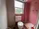 Bathroom in need of remodel with pink walls, toilet and window at 410 S Gordon Sw Rd, Mableton, GA 30126