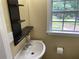 Bright bathroom with a modern sink, floating shelves, and a window offering outdoor views at 410 S Gordon Sw Rd, Mableton, GA 30126
