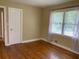 A simple bedroom featuring hardwood floors, neutral wall colors, and natural light from the large windows at 410 S Gordon Sw Rd, Mableton, GA 30126