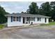 Charming home exterior featuring blue shutters, updated landscaping and a paved driveway at 410 S Gordon Sw Rd, Mableton, GA 30126