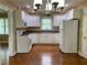 Well-lit kitchen with white cabinets, appliances, and hardwood floors at 410 S Gordon Sw Rd, Mableton, GA 30126