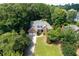 Stunning aerial view of a brick home surrounded by mature trees, with a well-manicured lawn and a two-car garage at 10880 Windham Way, Alpharetta, GA 30022