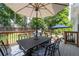 Outdoor wooden deck area showcasing a dining table with a shade umbrella and outdoor chairs at 10880 Windham Way, Alpharetta, GA 30022