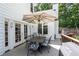 Outdoor wooden deck area showcasing a dining table with a shade umbrella and outdoor chairs at 10880 Windham Way, Alpharetta, GA 30022