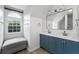 Bright bathroom with double sink vanity, large mirror, and arched window with cushioned bench at 10880 Windham Way, Alpharetta, GA 30022