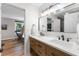 Bathroom with wood vanity, double sinks, black fixtures, and an adjoining office space at 10880 Windham Way, Alpharetta, GA 30022
