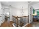Upstairs hallway with hardwood floors, decorative banister, and lots of natural light at 10880 Windham Way, Alpharetta, GA 30022
