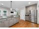 Open kitchen with stainless steel refrigerator, granite countertops, and hardwood floors at 10880 Windham Way, Alpharetta, GA 30022