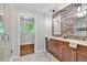 Bright bathroom featuring a double sink vanity with stone accent wall and herringbone tile floor at 620 Amberidge Trl, Atlanta, GA 30328