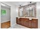 Bright bathroom featuring a double sink vanity with stone accent wall and herringbone tile floor at 620 Amberidge Trl, Atlanta, GA 30328
