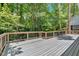 Large deck with railing surrounded by mature trees, offering a serene outdoor space at 620 Amberidge Trl, Atlanta, GA 30328