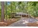 Charming brick home with covered porch, carport, and beautifully landscaped front yard with mature trees at 620 Amberidge Trl, Atlanta, GA 30328