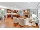 Open living room with hardwood floors, stacked stone fireplace, and kitchen featuring a large island at 620 Amberidge Trl, Atlanta, GA 30328
