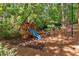 Backyard playground with slide and wood mulch surrounded by mature trees and landscaping at 620 Amberidge Trl, Atlanta, GA 30328