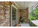 Inviting front porch with brick detail, stylish lighting, and a view of the surrounding greenery at 2973 Payton Ne Rd, Atlanta, GA 30345