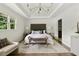 Elegant main bedroom with tray ceiling, large window and seating bench at foot of bed at 2973 Payton Ne Rd, Atlanta, GA 30345