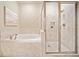 A bathroom features a soaking tub, frameless glass shower, and neutral-toned tiles at 326 Roswell Se St # 406, Marietta, GA 30060