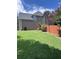 Home exterior featuring a grassy lawn, wooden fence, mature tree, and two stories at 3560 Elinburg Dr, Buford, GA 30519