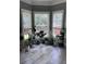 Light-filled sunroom with tile floors, multiple windows, and an array of lush plants and natural light at 3560 Elinburg Dr, Buford, GA 30519