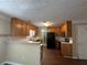 Functional kitchen featuring wood cabinets, black appliances, and a cozy breakfast bar at 4189 Duncan Ives Dr, Buford, GA 30519