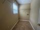 Practical laundry room featuring tiled floors, shelving for storage, and natural light from the window at 4189 Duncan Ives Dr, Buford, GA 30519