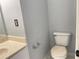Powder bathroom featuring neutral walls, a toilet, and single sink at 795 Abbotts Mill Ct # 73, Johns Creek, GA 30097